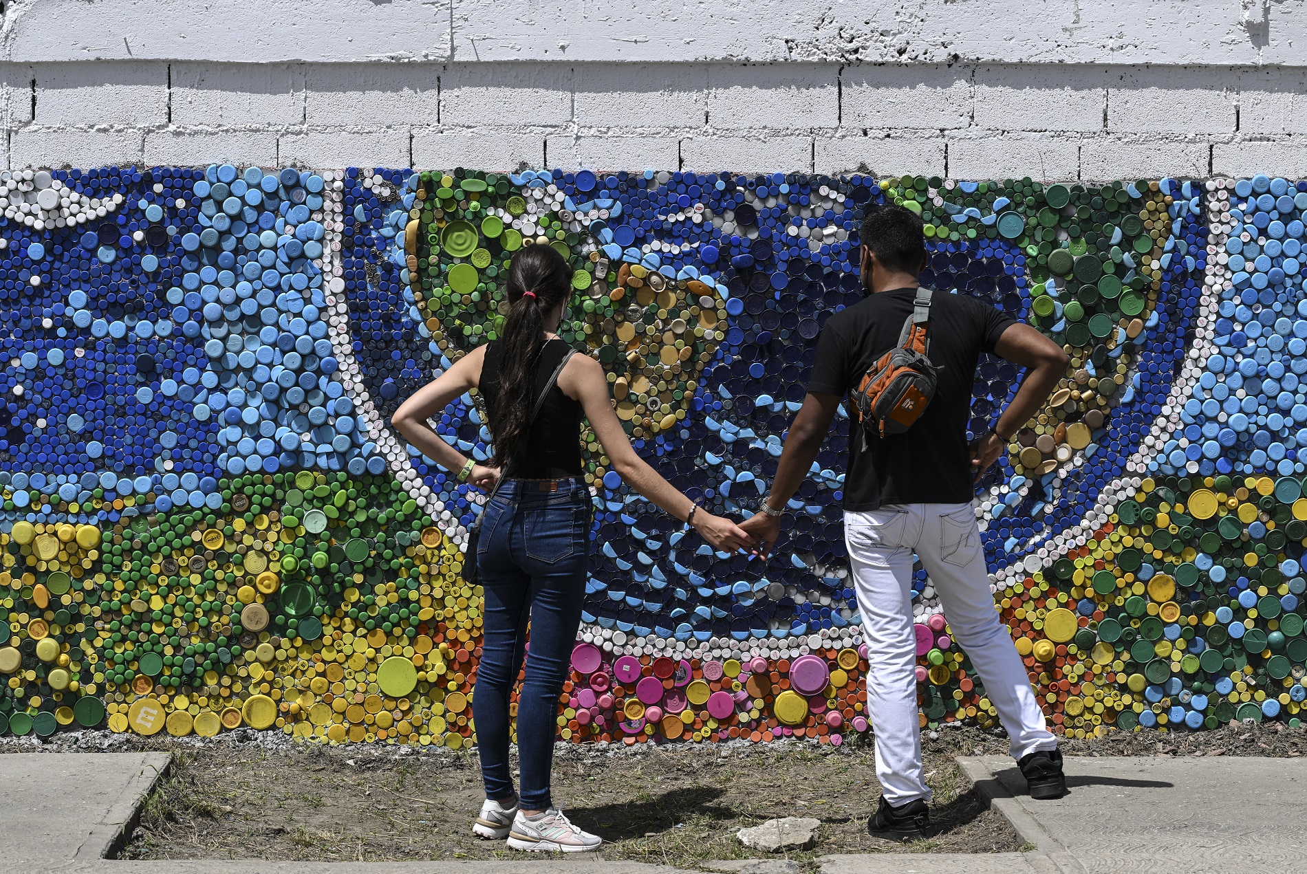 El artista venezolano Oscar Olivares crea murales con tapas de botellas