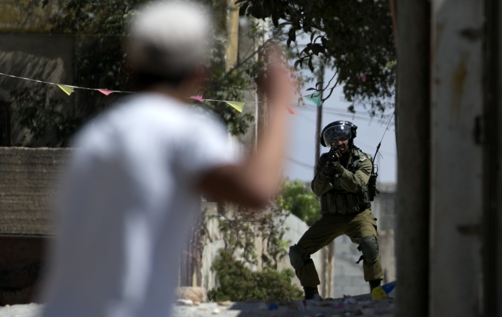 Un soldado israelí mientras tomaba como blanco a un palestino quien protesta la expropiación de las tierras palestinas por parte de Israel en Kafr Qaddum, cerca de Nablus.