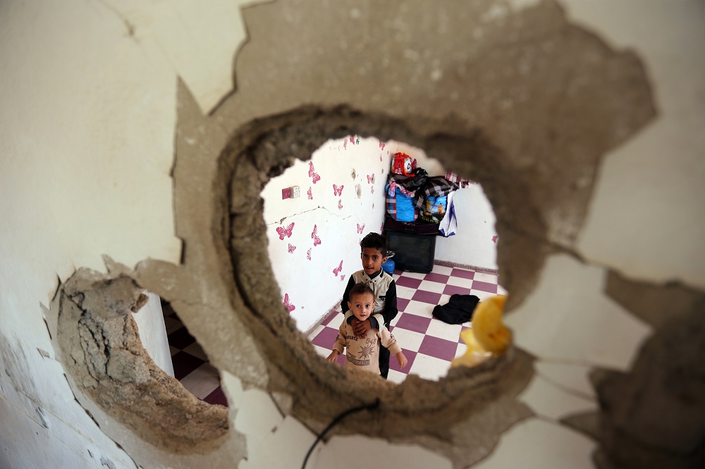 Familia que sigue viviendo en una casa bombardeada.