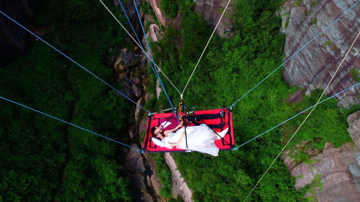 一对中国新人在玻璃桥悬空吊床上举行极限婚礼