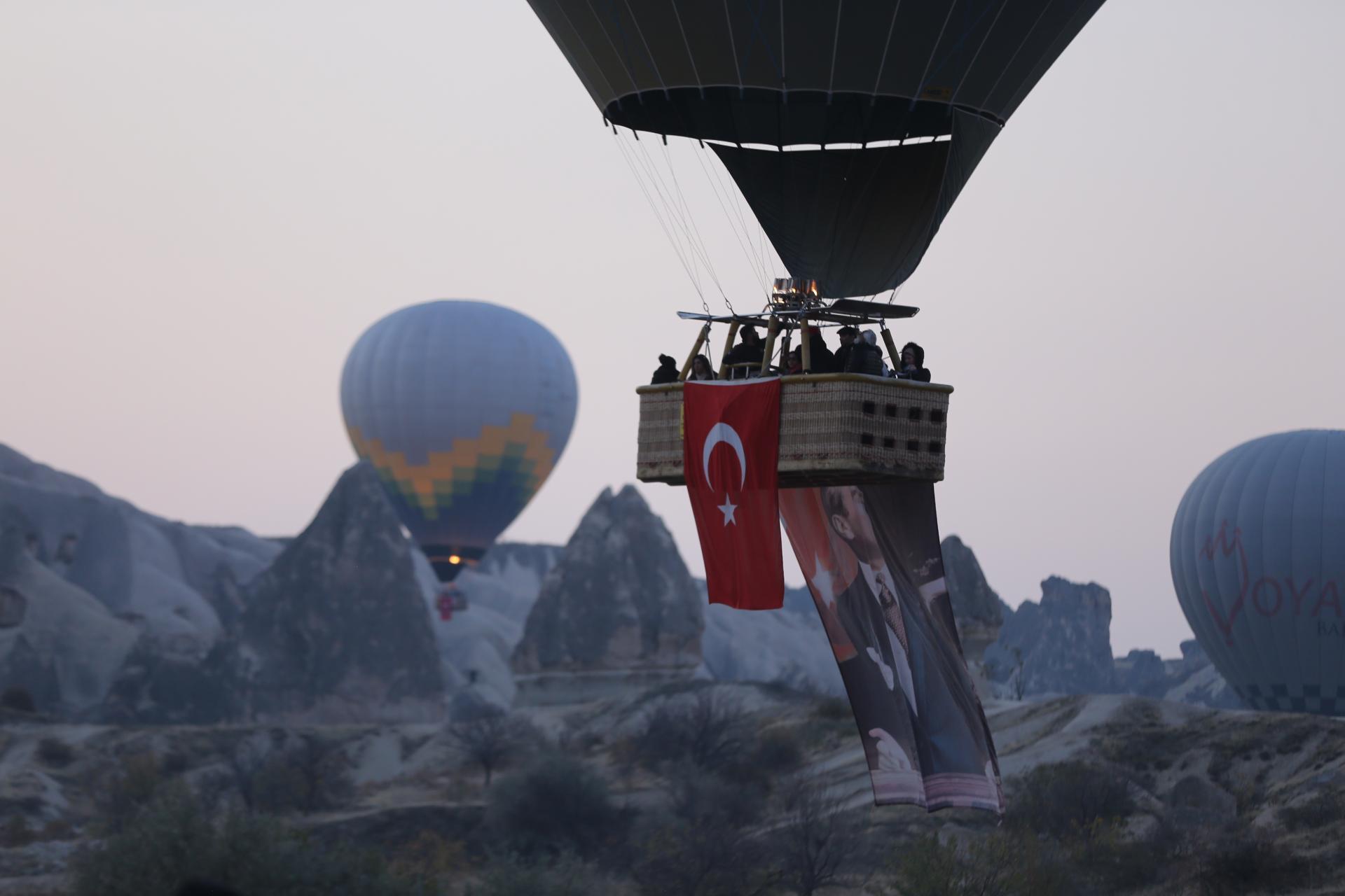 Kapadokya - Balonat sot fluturuan me flamurin turk dhe posterin e Ataturkut