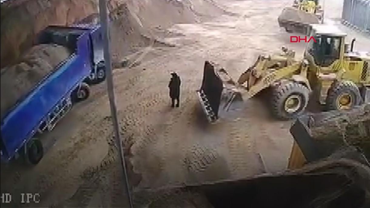 挖掘机操作员将一名女子连同沙土一起倒入大卡车里